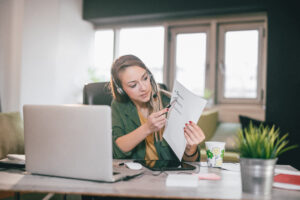 A female tutor wearing a headset with a microphone, engaged in an online teaching session